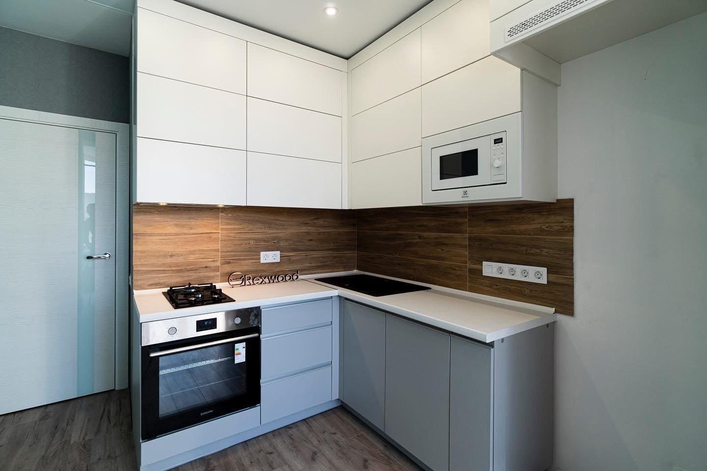 Compact White & Grey Handleless L-Shaped Kitchen with Woodgrain Splashback — 2