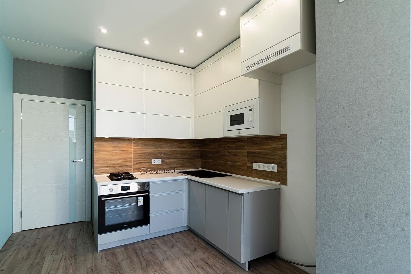 Compact White & Grey Handleless L-Shaped Kitchen with Woodgrain Splashback