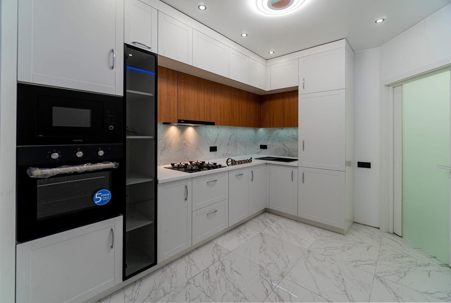 White Shaker & Oak L-Shaped Kitchen with Black-Framed Glass Column